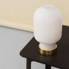 Minimalistyczna lampa stołowa AMP Brass white-brass ze szkła i mosiądzu marki Normann Copenhagen