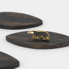 złota przypinka w kształcie spacerującego, czarnego borsuka