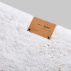 Detale pluszowego dywanika Purity w kolorze białym od take a NAP
